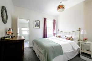 ein Schlafzimmer mit einem großen weißen Bett und einem Spiegel in der Unterkunft Chester Stays - Lovely 2 bedroom house in the heart of Chester in Chester