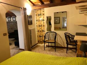 a bedroom with a bed and chairs in a room at VITERBO ART APARTMENTS in Viterbo