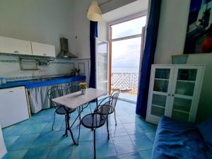 eine Küche mit einem Tisch und Stühlen im Zimmer in der Unterkunft Maridea - In Riva al Mare in Ponza