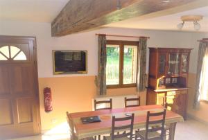 a dining room with a wooden table and chairs at Gîte de La Petite Ferme in Criquetot-le-Mauconduit