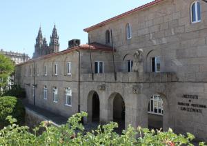 サンティアゴ・デ・コンポステーラにあるSan Clemente by Pousadas de Compostelaの時計塔を背景にした古い石造りの建物