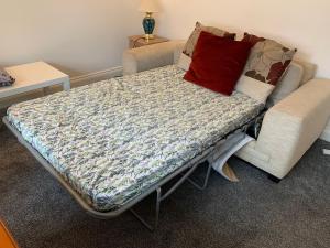 a hospital bed with a red pillow on it at Bournemouth Cozy 3 Bedrooms Near Beach With Parking in Bournemouth