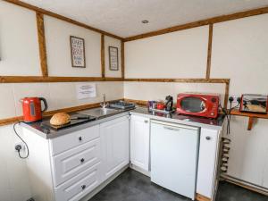 une petite cuisine avec un évier et un micro-ondes dans l'établissement Rose Cottage, à Llandysul 17 autres photos