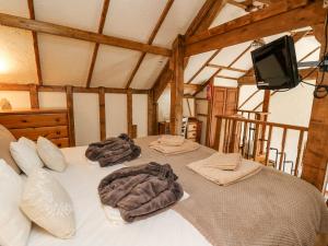 Cette chambre comprend un lit avec des draps blancs et une télévision. dans l'établissement Rose Cottage, à Llandysul