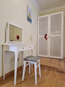 escritorio blanco con TV y silla en Casa Stella, en Pietrasanta