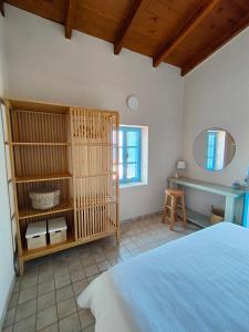 1 dormitorio con cama blanca y espejo en Villa Maistro, en Mókhlos