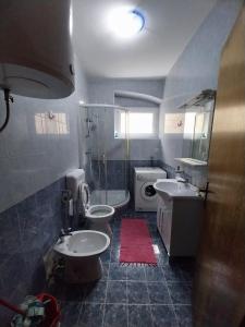 a bathroom with two sinks and a toilet at Apartmani Jadran in Mali Lošinj