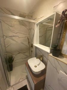 Un baño blanco con lavabo y espejo. en Room Lui, en Rijeka