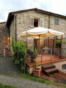 una terraza al aire libre con sombrilla y mesa en Casina Laura, en Capannori