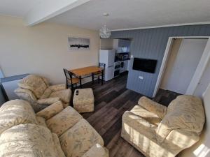 uma sala de estar com sofás e uma mesa e uma cozinha em Rosie's Place em Great Yarmouth