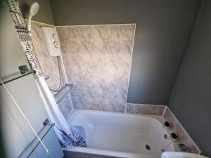 a bathroom with a white tub and a sink at Rosie's Place in Great Yarmouth