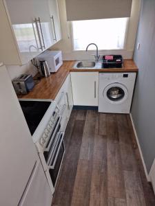 a small kitchen with a sink and a washing machine at Rosie's Place in Great Yarmouth