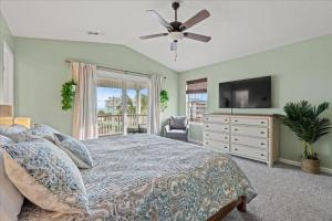 a bedroom with a bed and a flat screen tv at Mahalo House in Myrtle Beach