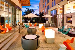 a patio with chairs and tables and umbrellas on a building at Aloft Philadelphia Airport in Philadelphia