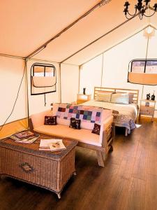 Una habitación con una cama y un sofá en una tienda de campaña en Silver Spur Homestead Luxury Glamping - The Cowboy, en Tombstone