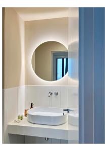 a white bathroom with a sink and a mirror at Imago Plus Hotel in Bari