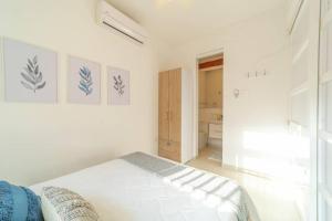 a white bedroom with a bed and a bathroom at C1-12 - Acogedor apartamento dentro de las murallas de Cartagena con aire acondicionado y agua caliente in Cartagena de Indias