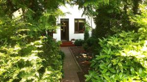 a small white house with a pathway leading to the front door at Pokoje z łazienkami Obiekt "PRZY ŻEGLARZY" in Ustka