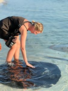 een vrouw in het water op het strand bij Omadhoo Coral View Inn in Omadhoo
