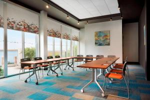 a conference room with tables and chairs and windows at Aloft Columbia Downtown in Columbia