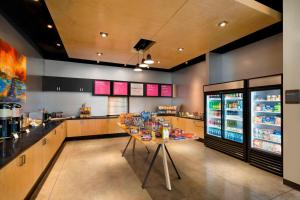 a large kitchen with a table and a refrigerator at Aloft Columbia Downtown in Columbia