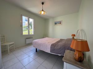 a bedroom with a bed and a table with a lamp at Appartement Meschers-sur-Gironde, 2 pièces, 4 personnes - FR-1-550-56 in Meschers-sur-Gironde