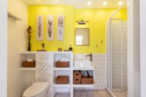 uma casa de banho com um WC e uma parede amarela em Yellow Studio Paupys em Vilnius