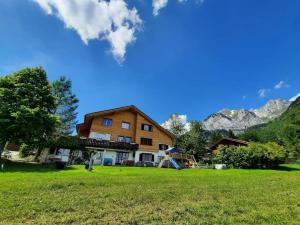 a house in a field with mountains in the background at Ferienwohnung Schafbergblick in Wildhaus