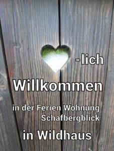 ein Herz auf einem hölzernen Tisch mit den Worten "hoch willushimaemia in der Feder" in der Unterkunft Ferienwohnung Schafbergblick in Wildhaus