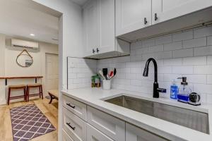 a kitchen with white cabinets and a sink at Beachside Retreat Awaits at Jacksonville Beach in Jacksonville Beach