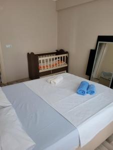 ein weißes Bett mit zwei blauen Handtüchern darauf in der Unterkunft Deniz Manzaralı in Arsin