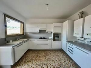 uma cozinha branca com armários brancos e uma janela em Central -300m Palais- Seaview-A/C-WIFI-spacieux em Cannes