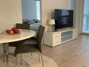 ein Wohnzimmer mit einem TV und einem Tisch mit einer Obstschale in der Unterkunft Hervannassa uusi saunallinen kaksio + Parkkipaikka + Ratikka in Hervanta