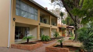 een gebouw met palmbomen ervoor bij Anka Lodge in Johannesburg