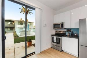 a kitchen with white cabinets and a large sliding glass door at Poolside Studio w Rooftop Deck - Walk to Old Town in Scottsdale