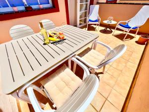 a white picnic table with chairs and a bottle of wine at !!! Relaxing View, The Heights Apartment With Terrace and Heated Pools, Los Cristianos in Los Cristianos +37 photos