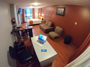 een woonkamer met een laptop op een bureau in een kamer bij El Peregrino Apart Hotel in Abancay