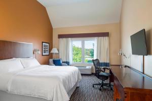 Buffalo GroveにあるFour Points by Sheraton Buffalo Groveのベッド、デスク、窓が備わるホテルルームです。