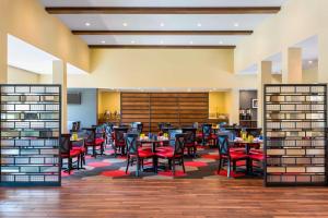 un comedor con mesas y sillas rojas en Four Points by Sheraton Buffalo Grove en Buffalo Grove
