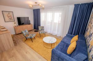 een woonkamer met een blauwe bank en stoelen bij Luxueux 3p. Art Deco + Parking in Cannes