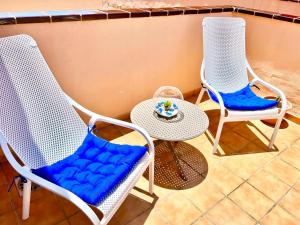 two chairs with blue cushions and a table with a plate on it at !!! Relaxing View, The Heights Apartment With Terrace and Heated Pools, Los Cristianos in Los Cristianos
