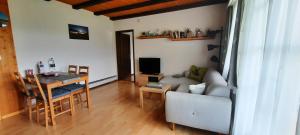 a living room with a table and a couch and a dining room at Ferienwohnung Schafbergblick in Wildhaus