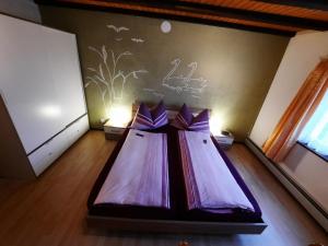 a room with a bed with purple sheets in it at Ferienwohnung Schafbergblick in Wildhaus