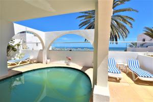 una piscina con sillas y vistas al océano en VILLA KIKA ZARZIS, LOCATION CHAMBRES D'HÔTES en TUNISIE en Zarzis