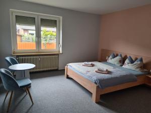 - une chambre avec un lit, une table et une fenêtre dans l'établissement Gästehaus Norddeich, à Norden