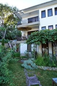 a house with a balcony and a bench in the yard at Tito's Place in Ohrid