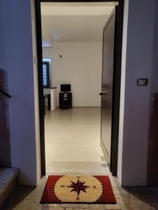 une porte ouverte menant à un couloir avec un tapis au sol dans l'établissement Loft Delle Scalette, à Nepi