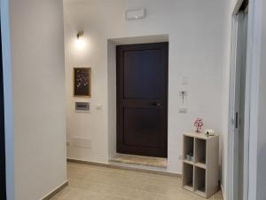 une porte noire dans un couloir blanc avec une table dans l'établissement Loft Delle Scalette, à Nepi