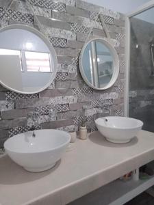 a bathroom with two sinks and mirrors on a counter at Viner's Inn in Tacloban +21 photos