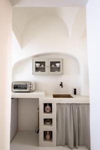 uma cozinha com um lavatório e um micro-ondas em moma Ostuni Boutique Home em Ostuni